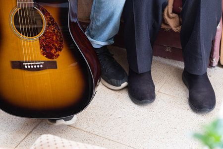 Grandson and grandfather together with a guitar next to them