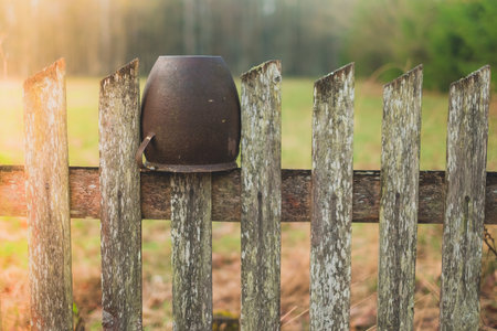 metal pot hanging on a wooden fence countryside
