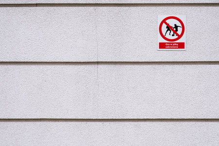 playing football forbidden text and pictogram in Polish on the wall in Warsaw Poland, crack in rough facadeの写真素材