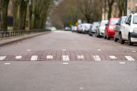 speed bump on empty street in Warsaw, Poland, cars on one side of the street, challenge symbol