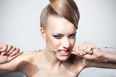 Girl bites the barbed wire, the conceptの写真素材