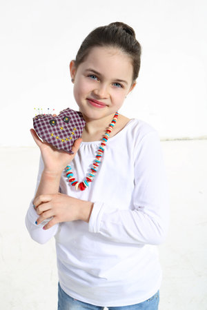 Girl posing with handmade toy isolated on whiteの写真素材