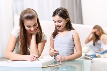 Two girls write something for a glass tableの写真素材