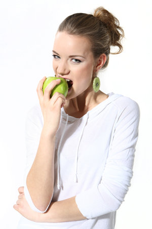 Girl with a green apple on a white backgroundの写真素材