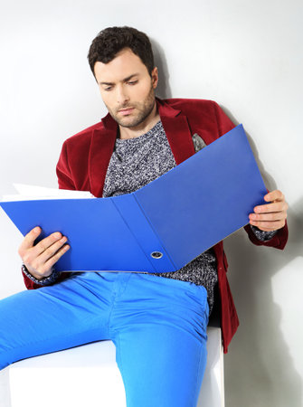 Portrait of businessman with a blue folder of documentsの写真素材