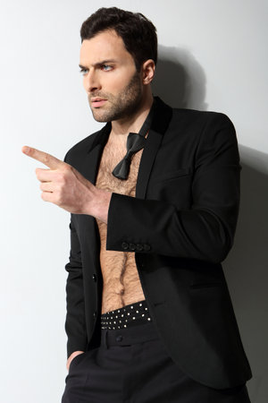 Great looking sexy male model with open shirt and loose bow tieの写真素材