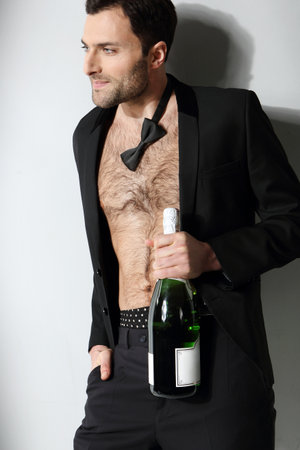 Sexy male model holding champagne bottle の写真素材