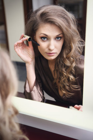 The young beautiful girl does makeupの写真素材