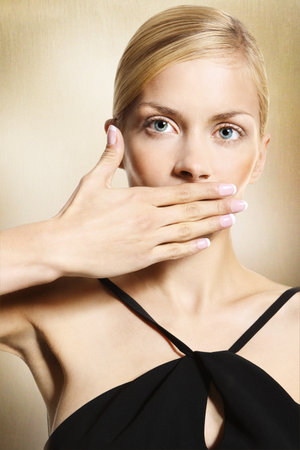 Woman covers her mouthの写真素材