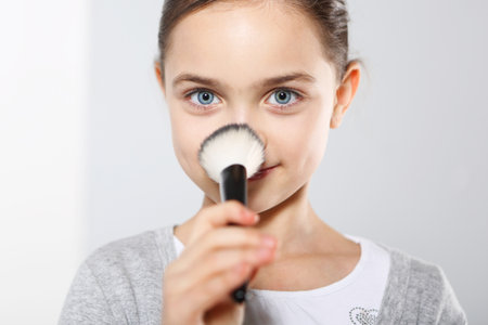 Pretty girl powdering her noseの写真素材