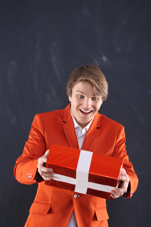 Man in orange jacket grabs a gift の写真素材