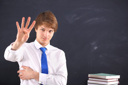 Male teacher showing four fingersの写真素材