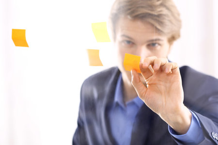 Office worker putting up notes の写真素材