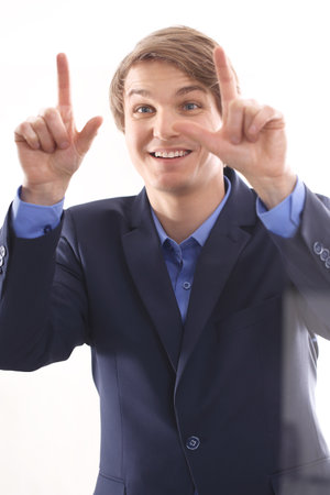  boy in a blue suit presses the finger on the screen の写真素材