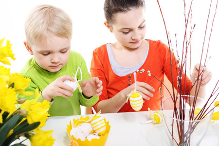 Siblings decorates Easter eggs の写真素材