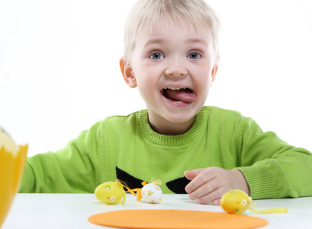 boy in a green sweater decorated Easter eggs の写真素材
