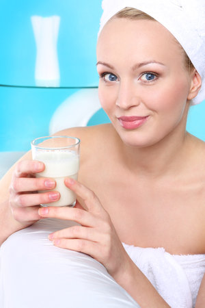 Almond milk-Health   Beauty   Portrait of a young woman sitting on the sofa with a glass of milk の写真素材