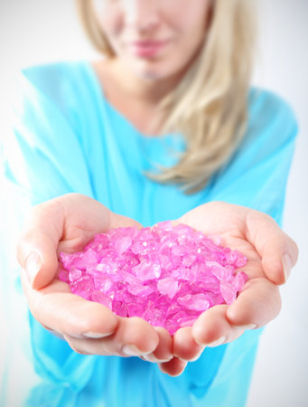 Female hands they keep colored crystals  Well groomed female hands they keep pink, pastel crystalsの写真素材