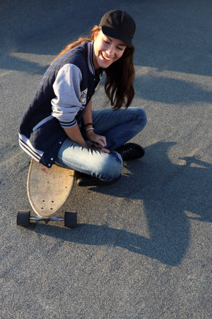 Style and play, skateboard.Young girl on the roof relaxes in the rays of the setting sun.Mloda dziewczyna na dachu relaksuje sie w promieniach zachodzacego slonca.Fot. Robert Przybysz / FORUMの写真素材