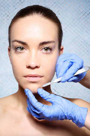 Caucasian woman during surgery using a scalpelの写真素材