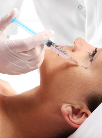 Caucasian woman during surgery using a scalpelの写真素材