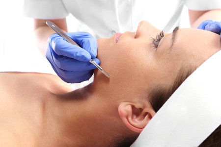 Caucasian woman during surgery using a scalpelの写真素材