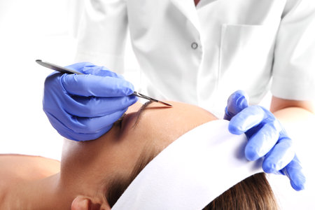 Caucasian woman during surgery using a scalpelの写真素材