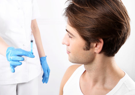 The young man is a nurse with syringeの写真素材
