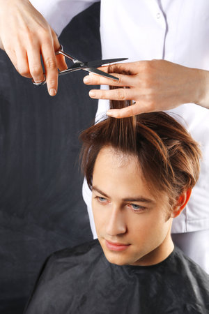 Portrait of a young white boy while cutting hair in the hair salonの写真素材