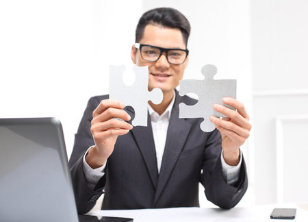 Businessman shows silver pieces of the puzzleの写真素材