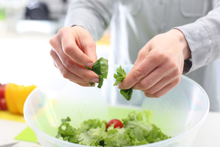 Lettuce, healthy food. Woman hands while preparing colorful saladsの写真素材
