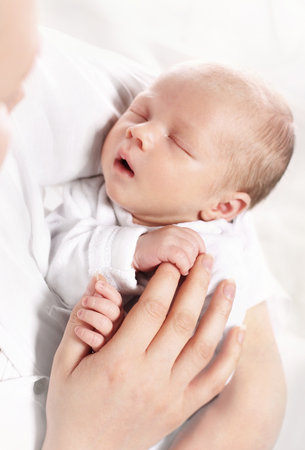 Infant. A woman holds in her arms her newborn babyの写真素材