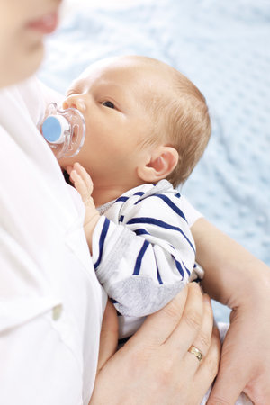 Infant. A woman holds in her arms her newborn babyの写真素材
