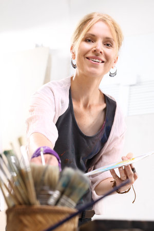 Mature woman in the painting studioの写真素材