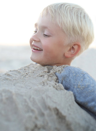Child on beach Cheerful little boy playing in the sand on the beachの写真素材