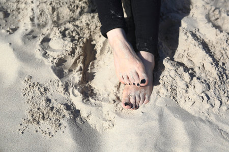 Woman's foot. Feet of a woman buried in sand on the beachの写真素材