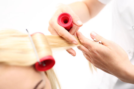 Hair rollers. A woman in a hair salon, barber turns hair on rollersの写真素材