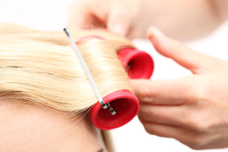 The woman at the hairdresser, twirling hair curlersの写真素材