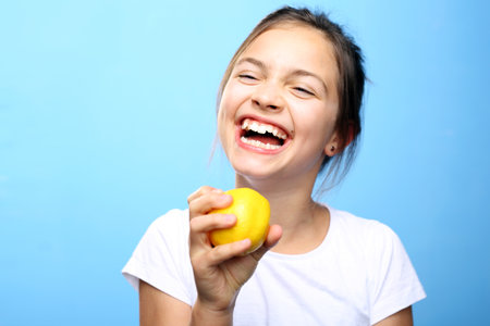 Child with lemon. Pretty girl licks fruit lemonの写真素材