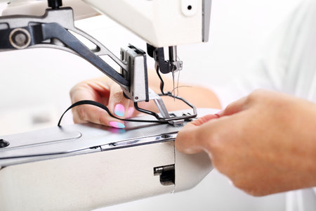 Sewing machine. Seamstress sewing on the sewing machine in the manufacturing plantの写真素材