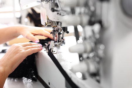 Seamstress. Seamstress sewing on the sewing machine in the manufacturing plantの写真素材