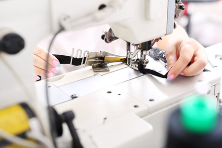 Seamstress sewing on the sewing machine in the manufacturing plantの写真素材