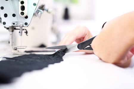 Factory, sewing room. Seamstress sewing on the sewing machine in the manufacturing plantの写真素材