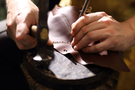 Shoemaker. Cobbler shoemaker sews elegant shoesの写真素材