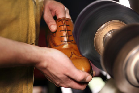 Polishing shoes. Polisher cobbler polishes on brown shoesの写真素材