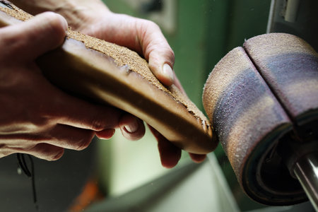 Shoemaker. Grinding shoes in shoe manufacturing plantの写真素材