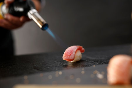 Portion of rice formed into a ball covered with a piece of fishの写真素材