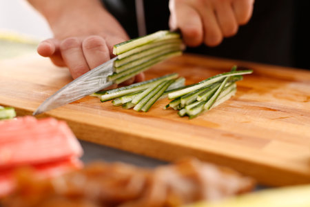 Master sushi knife slicing sushi rollsの写真素材