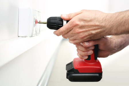 Man mounts in a wall electrical outlet, Internet connectionの写真素材