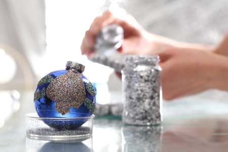 woman showering Christmas bauble silver glitter.の写真素材